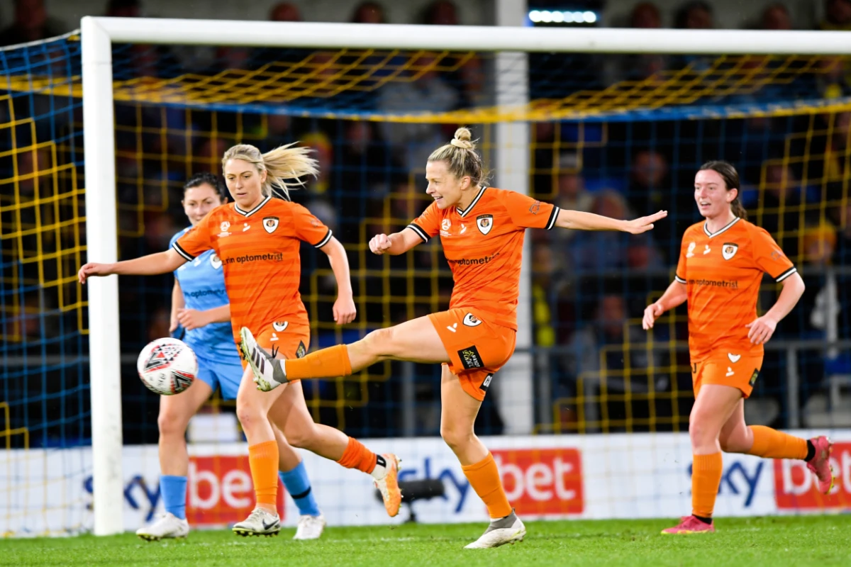 Women's team attacking in front of goal